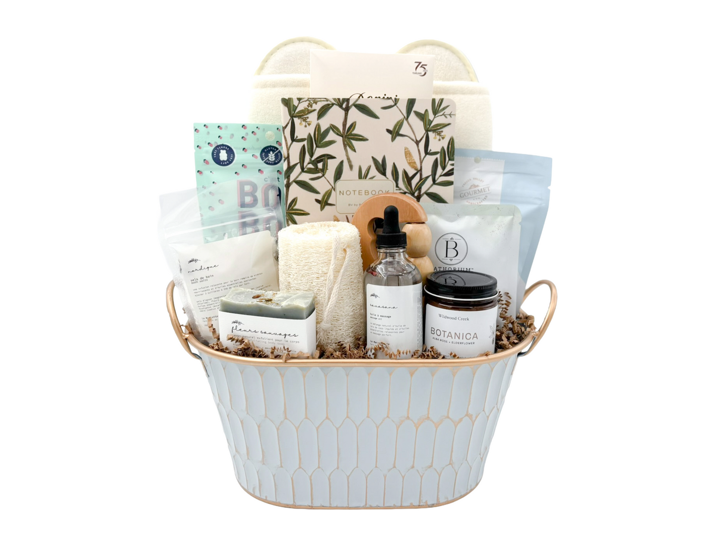 Gift basket with various items including candles, soap, and bath products on a white background