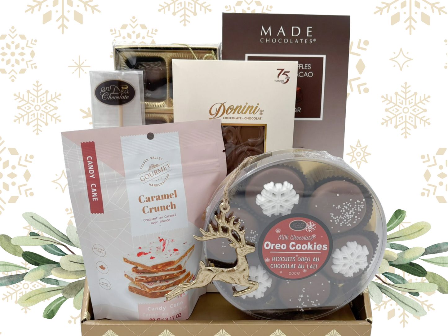 Assorted food items including cookies, candy, and chocolate in a decorative box with a festive background.