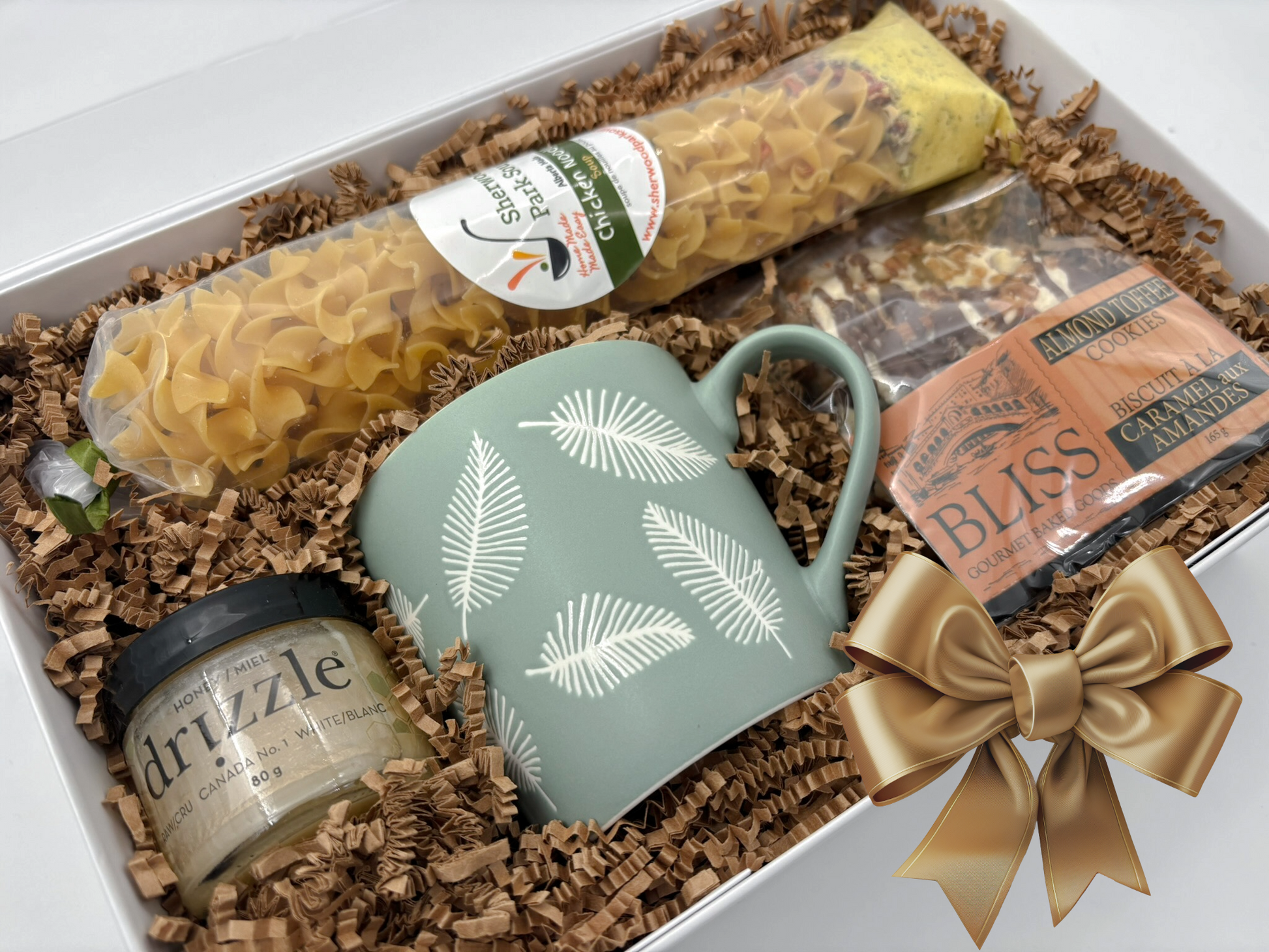 Gift basket with mug, pasta, and other items on a white background