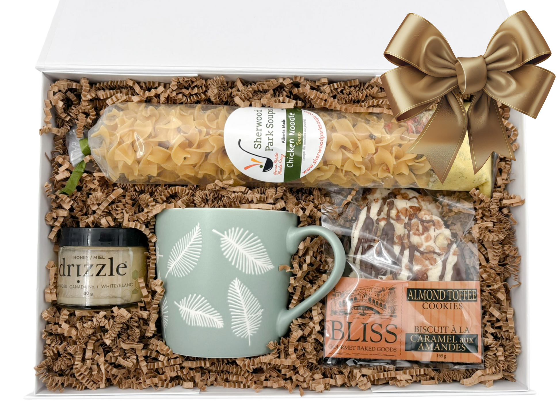 Gift basket with mug, cookies, and other items on crinkled paper