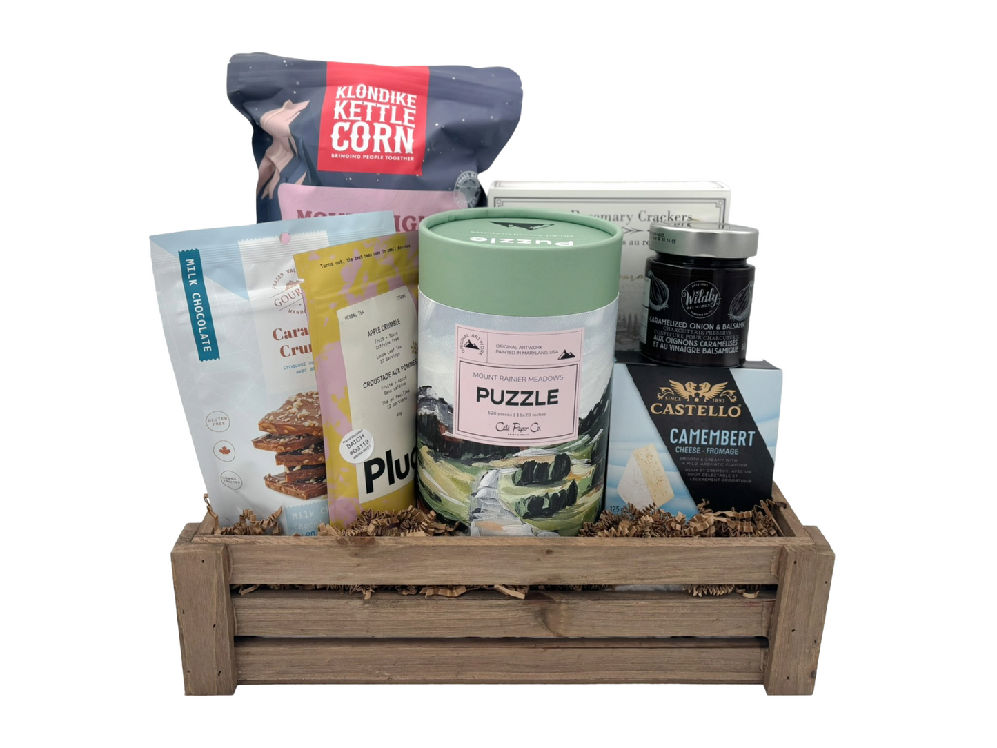 gift basket containing popcorn, cheese, crackers, tea, and other snacks plus a puzzle on a white background