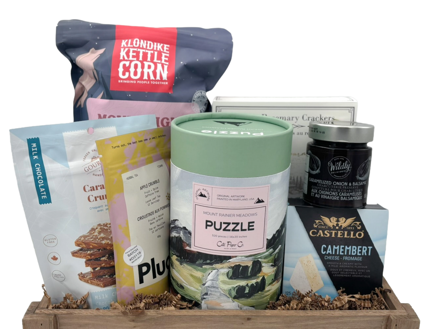 gift basket containing popcorn, cheese, crackers, tea, and other snacks plus a puzzle on a white background.