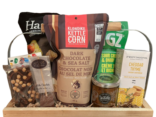 Assorted snacks and treats in a wooden basket with visible brand names.
