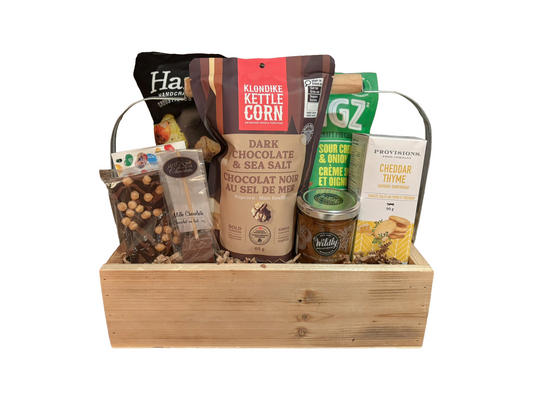 Gift basket with various snacks and treats in a wooden box on a white background
